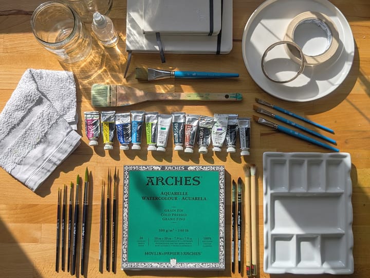Photo displays a desk with art supplies laid out in an organized manner.